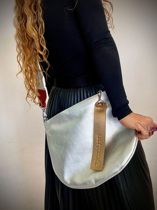 Arco Bag Silver — metallic silver leather crossbody bag with adjustable strap, worn by model | LULÉ LULÉ