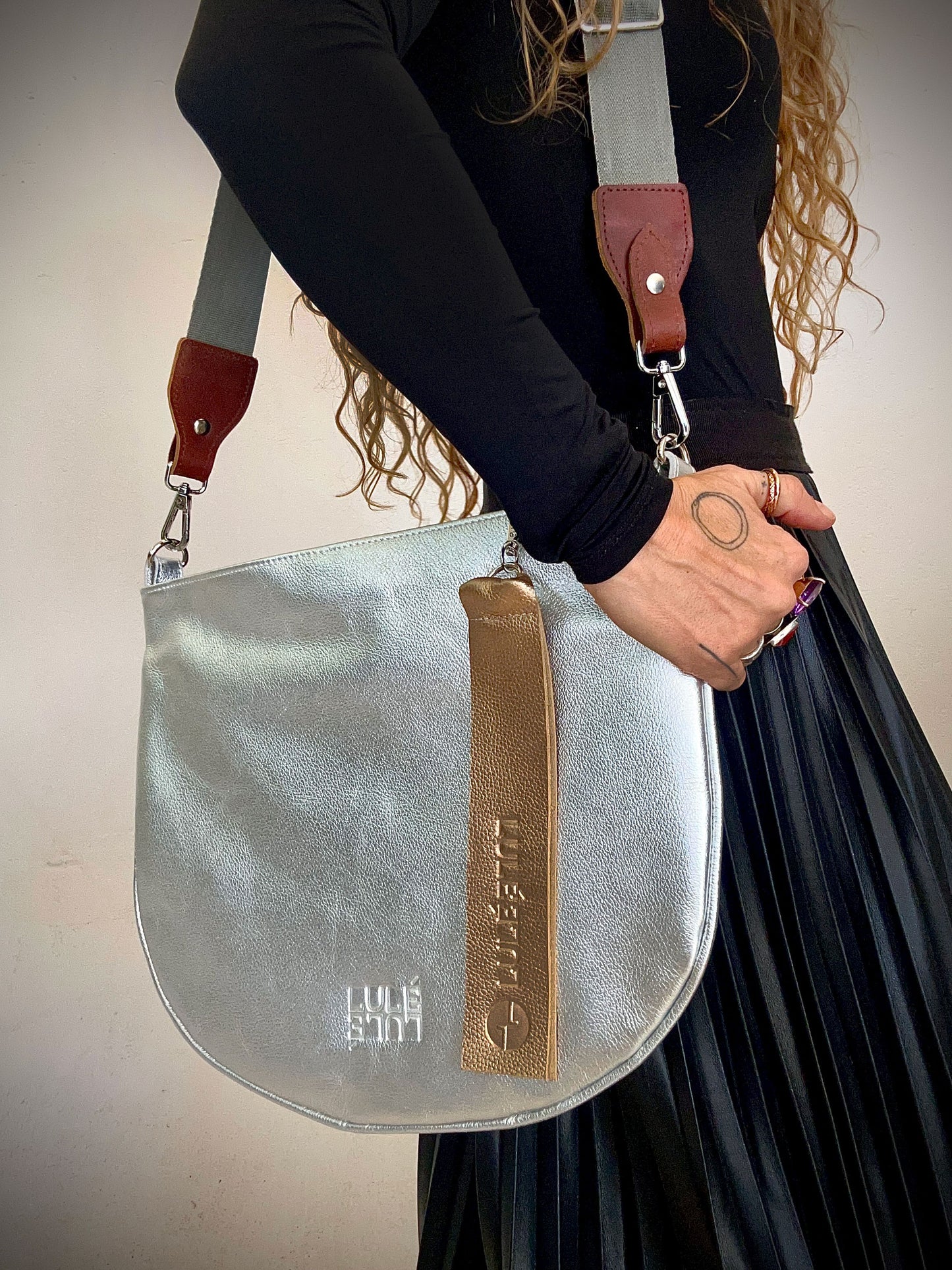 Arco Bag Silver — handcrafted Colombian leather crossbody bag, silver with gold pull tab and LULÉ LULÉ embossed logo | LULÉ LULÉ