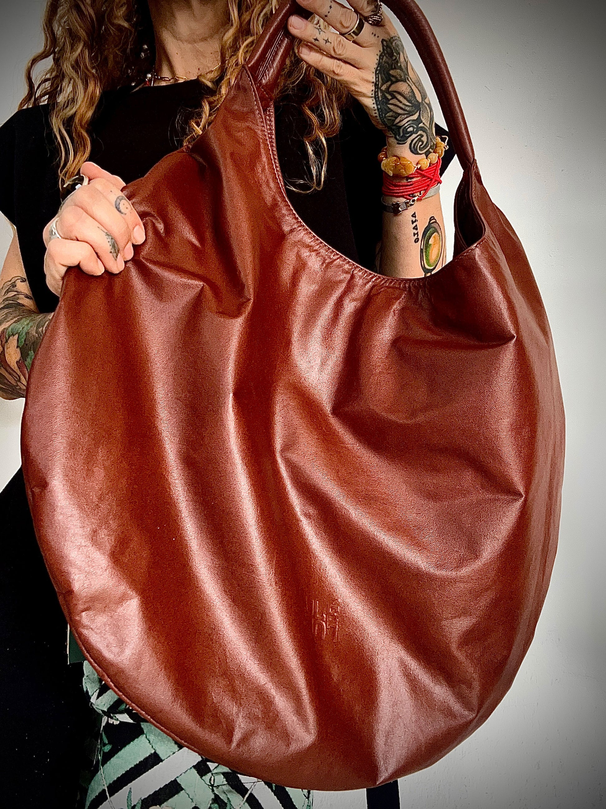 LULÉ LULÉ O.G. Bag in terracotta leather, close-up of embossed logo and soft drape